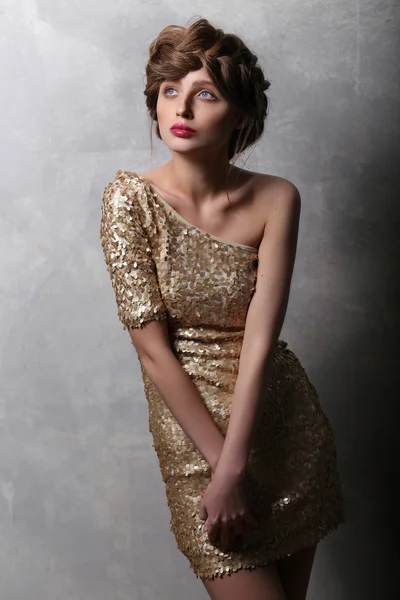Portrait beautiful girl model in a gold dress. — Stok fotoğraf