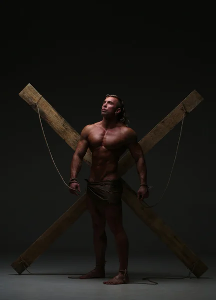 Hombre desnudo sexual, musculoso, manos atadas cuerda a vigas de madera — Foto de Stock