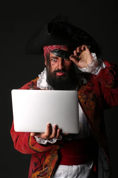 Retrato del hombre sorprendido en un disfraz de pirata con portátil — Foto de Stock