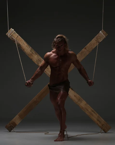 Сексуальный голый мужчина, мускулистый, руки связаны веревкой с деревянными балками — стоковое фото