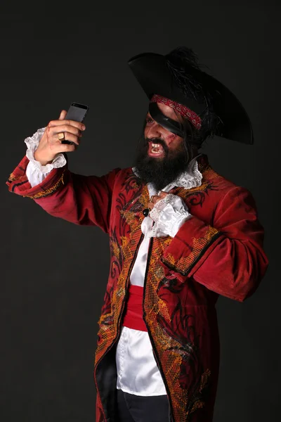 Hombre en un traje de pirata con teléfono móvil, se hace uno mismo — Foto de Stock