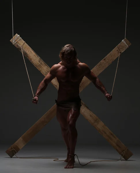 Sexual naked man, muscular, hands tied rope to wooden beams — Stock Photo, Image