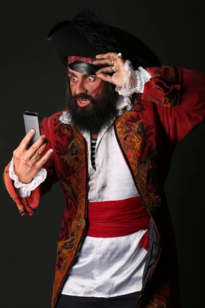 Retrato del hombre sorprendido disfrazado de pirata con teléfono móvil — Foto de Stock