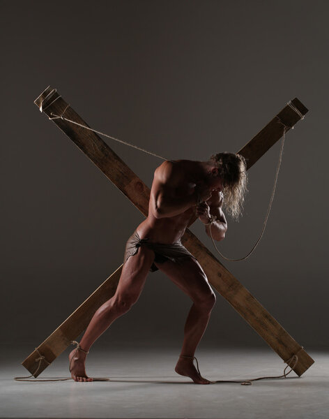 Sexual naked man, muscular, hands tied rope to wooden beams