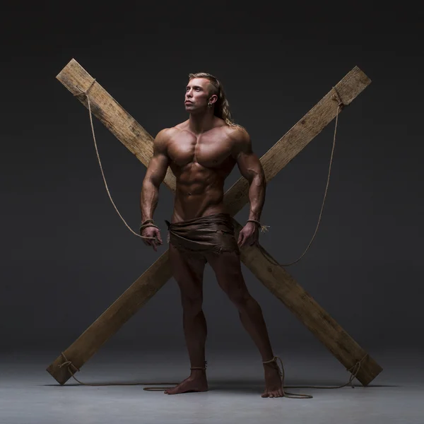 Sexual naked man, muscular, hands tied rope to wooden beams — Stock Photo, Image