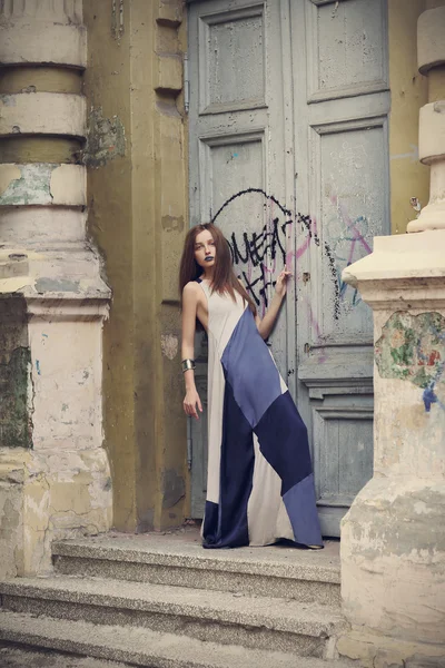 Retrato de moda de cuerpo entero mujer moderna de pie cerca de la puerta vieja — Foto de Stock