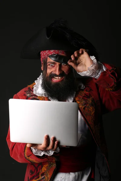 Retrato del hombre sorprendido en un disfraz de pirata con portátil — Foto de Stock