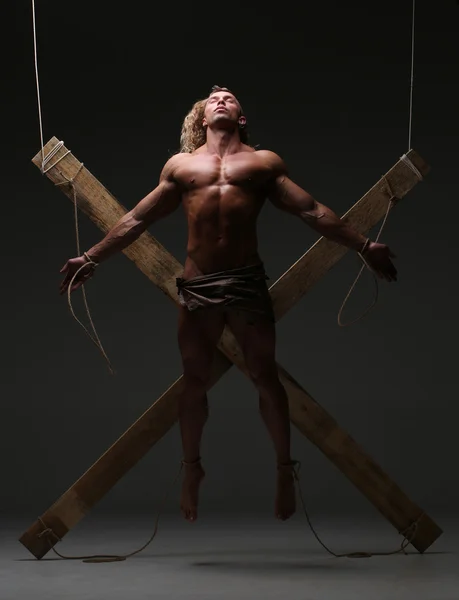 Sexual naked man, muscular, hands tied rope to wooden beams — Stock Photo, Image