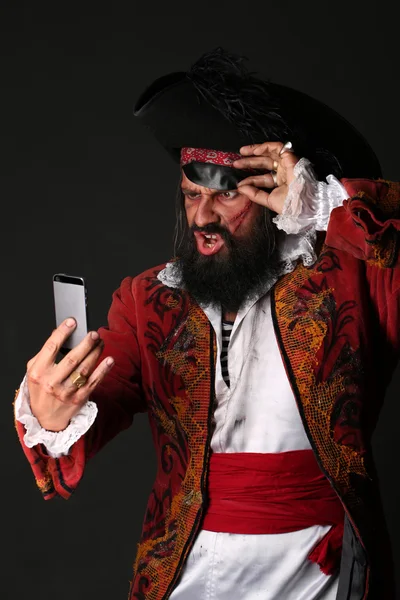 Retrato del hombre sorprendido disfrazado de pirata con teléfono móvil — Foto de Stock
