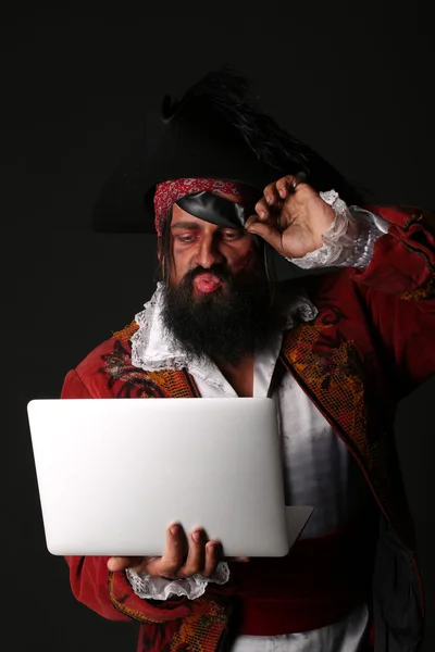 Retrato del hombre en un disfraz de pirata con portátil — Foto de Stock