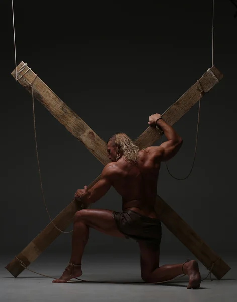 Hombre desnudo sexual, musculoso, manos atadas cuerda a vigas de madera — Foto de Stock