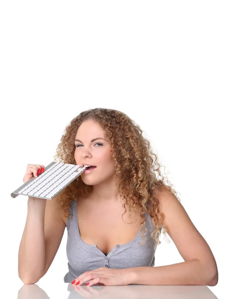 Mujer linda, pelo rizado rojo, sentado con teclado en los dientes — Foto de Stock