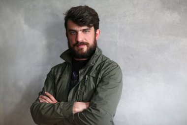 Çapraz elle haki ceketli adamı gülümseyerek. Siyah Close.up.