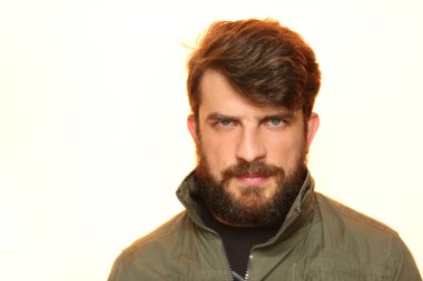 Sakallı adam ilginç bakışla haki ceket giymiş. Beyaz Close.up.