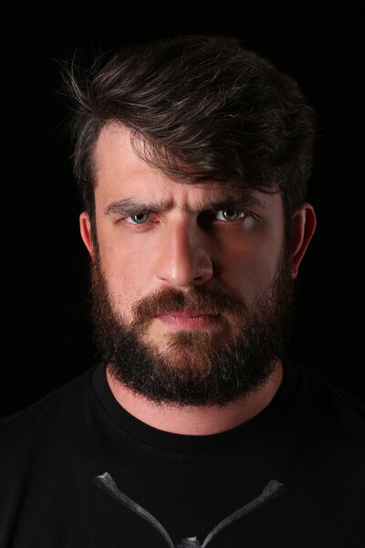 Bearded guy wearing shirt with serious look. Close.up. Black