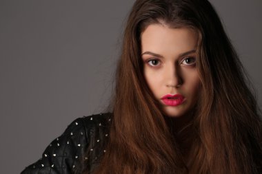 Kız çivili deri ceketli. Yakın çekim. Beyaz arka plan