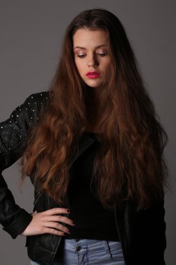 Kız bir çivili deri ceket poz. Yakın çekim. Beyaz arka plan