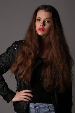 Kız onu kalça üzerinde el ile çivili deri ceketli. Yakın çekim. Beyaz arka plan