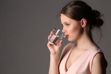 Bayan pembe en iyi içme suyu. Yakın çekim. Gri arka planı