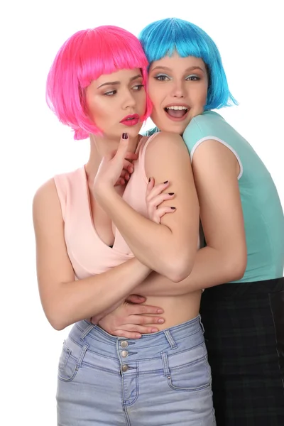 Girls in colorful wigs hugging. Close up. White background — Stock Photo, Image