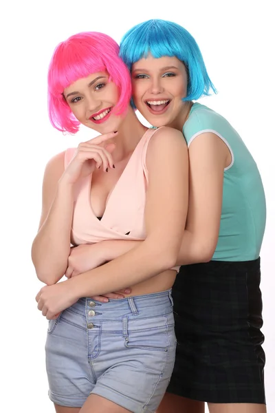 Adolescentes em perucas coloridas abraçando. Fecha. Fundo branco — Fotografia de Stock