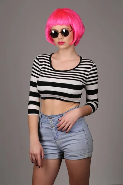 Teenager mit Sonnenbrille und rosa Haaren posieren. Nahaufnahme. grauer Hintergrund — Stockfoto