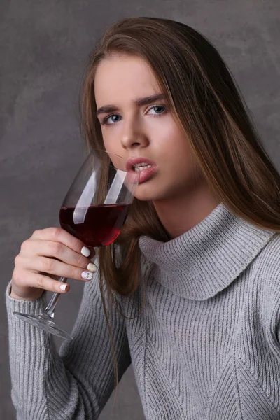 Dame trinkt Wein. Nahaufnahme. grauer Hintergrund — Stockfoto