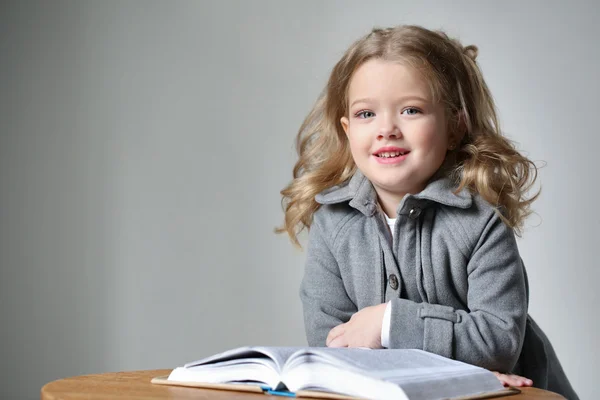 Porträt eines Mädchens mit einem Buch. Nahaufnahme. grauer Hintergrund — Stockfoto