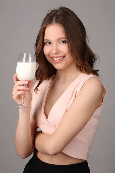 Lady stwarzające z kieliszek do wina mleka. Z bliska. Szare tło — Zdjęcie stockowe
