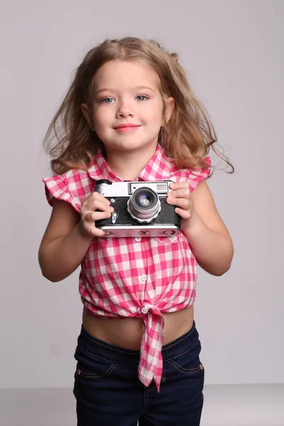 Porträtt av en tjej med kamera. Närbild. Grå bakgrund — Stockfoto