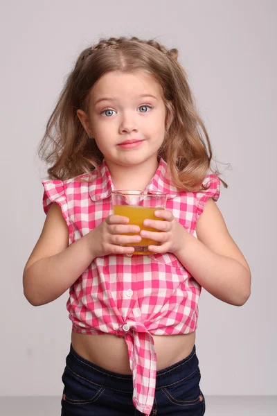 Lady i pläd skjorta med ett glas juice. Närbild. Grå bakgrund — Stockfoto