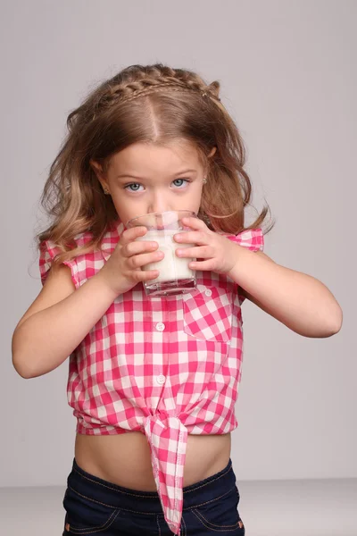 Portrait of a baby drinking milk. Close up. Gray background