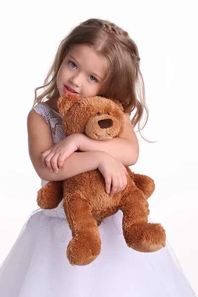 Enfant en robe de mariée avec ours. Ferme là. Fond blanc — Photo