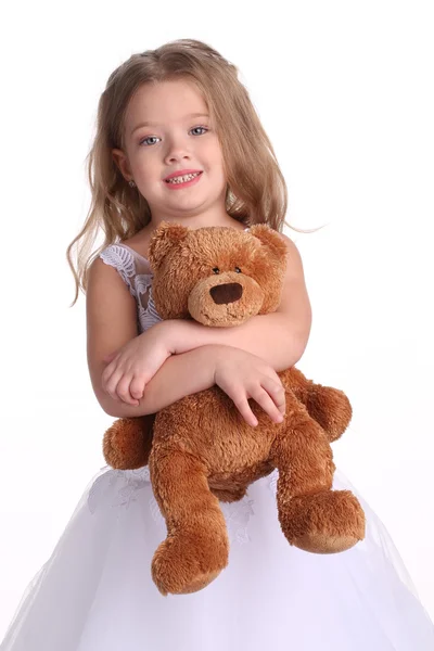 Klein meisje in trouwjurk met beer. Close-up. Witte achtergrond — Stockfoto