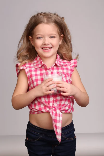 Menina de camisa xadrez com um copo de leite. Fecha. Fundo cinzento — Fotografia de Stock