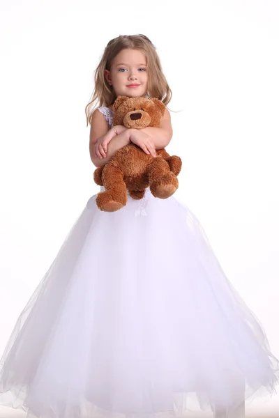 Дитина у весільній сукні з ведмедем. Білий фон — стокове фото