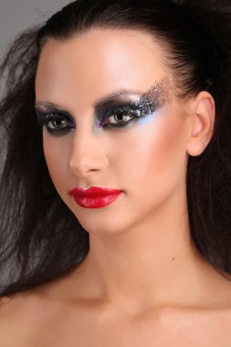 Dumanlı gözleri ve vahşi saçlı model. Yakından kapatın. Gri arka plan
