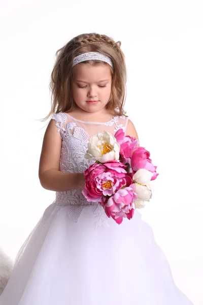 Liten flicka i bröllopsklänning. Närbild. Vit bakgrund — Stockfoto
