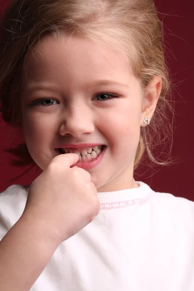 Menina bebê tocando seus dentes. Fecha. Fundo vermelho — Fotografia de Stock