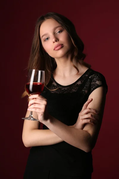 Model z winem i skrzyżowanymi ramionami. Z bliska. Ciemnoczerwone tło — Zdjęcie stockowe