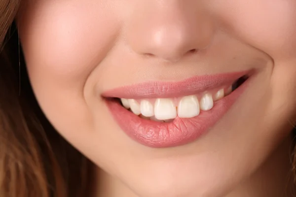 Una chica sonriente mordiéndose el labio. De cerca. — Foto de Stock
