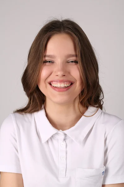 Rapariga sorridente de t-shirt. Fecha. Fundo branco — Fotografia de Stock