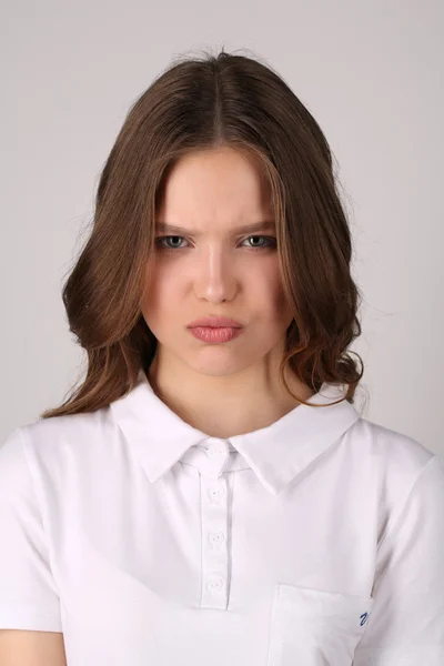 Chica Seious en camiseta. De cerca. Fondo blanco — Foto de Stock