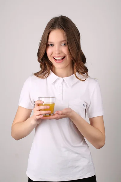 Lady poserar med glas juice. Närbild. Vit bakgrund — Stockfoto