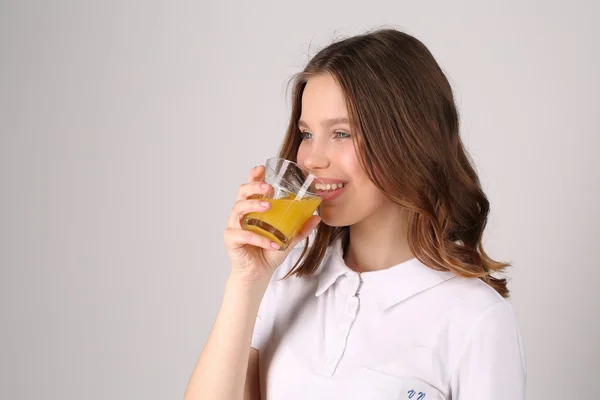 Tonåring dricka juice. Närbild. Vit bakgrund — Stockfoto