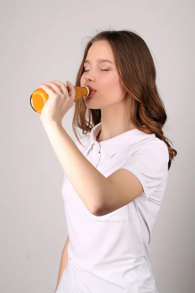 Flicka i Polo dricker apelsinjuice. Närbild. Vit bakgrund — Stockfoto