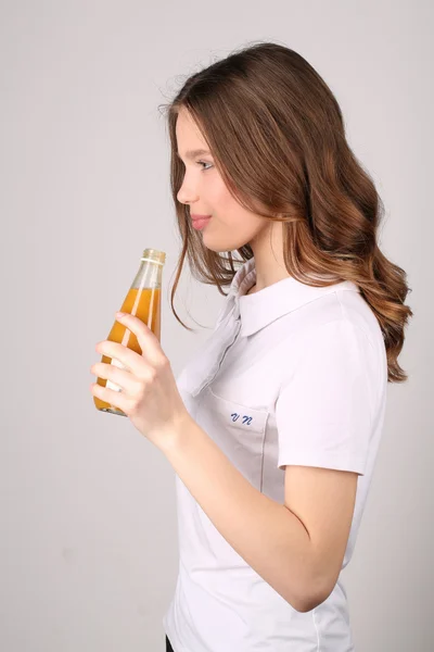 Lady stående profil med juice. Närbild. Vit bakgrund — Stockfoto