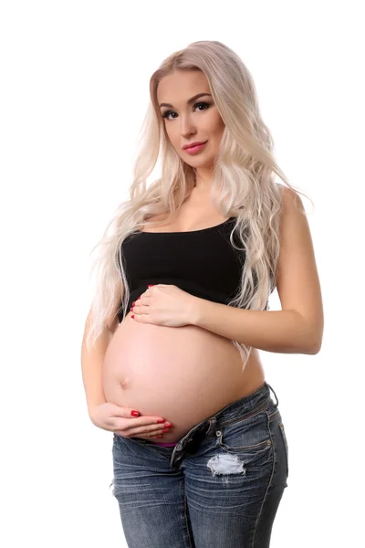 Mujer embarazada con las manos sobre la barriga. De cerca. Fondo blanco — Foto de Stock