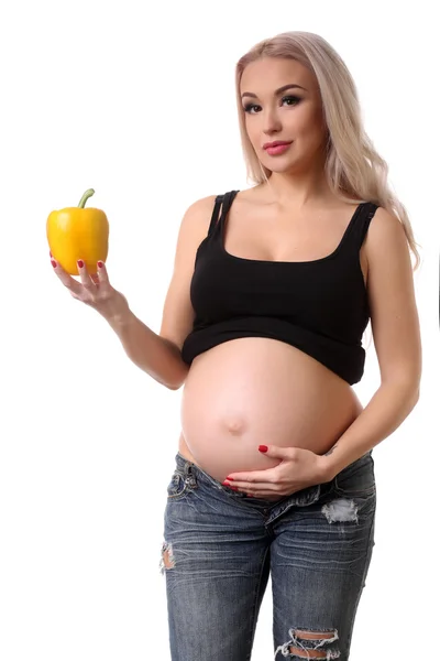 Gravid kvinna med gul peppar. Närbild. Vit bakgrund — Stockfoto