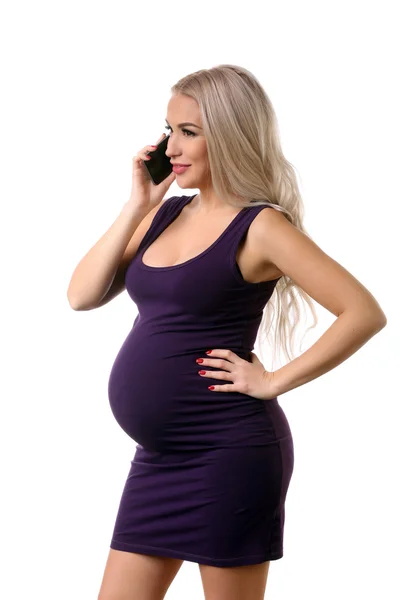W ciąży dziewczyna w sukni rozmawia przez telefon. Z bliska. Białe tło — Zdjęcie stockowe
